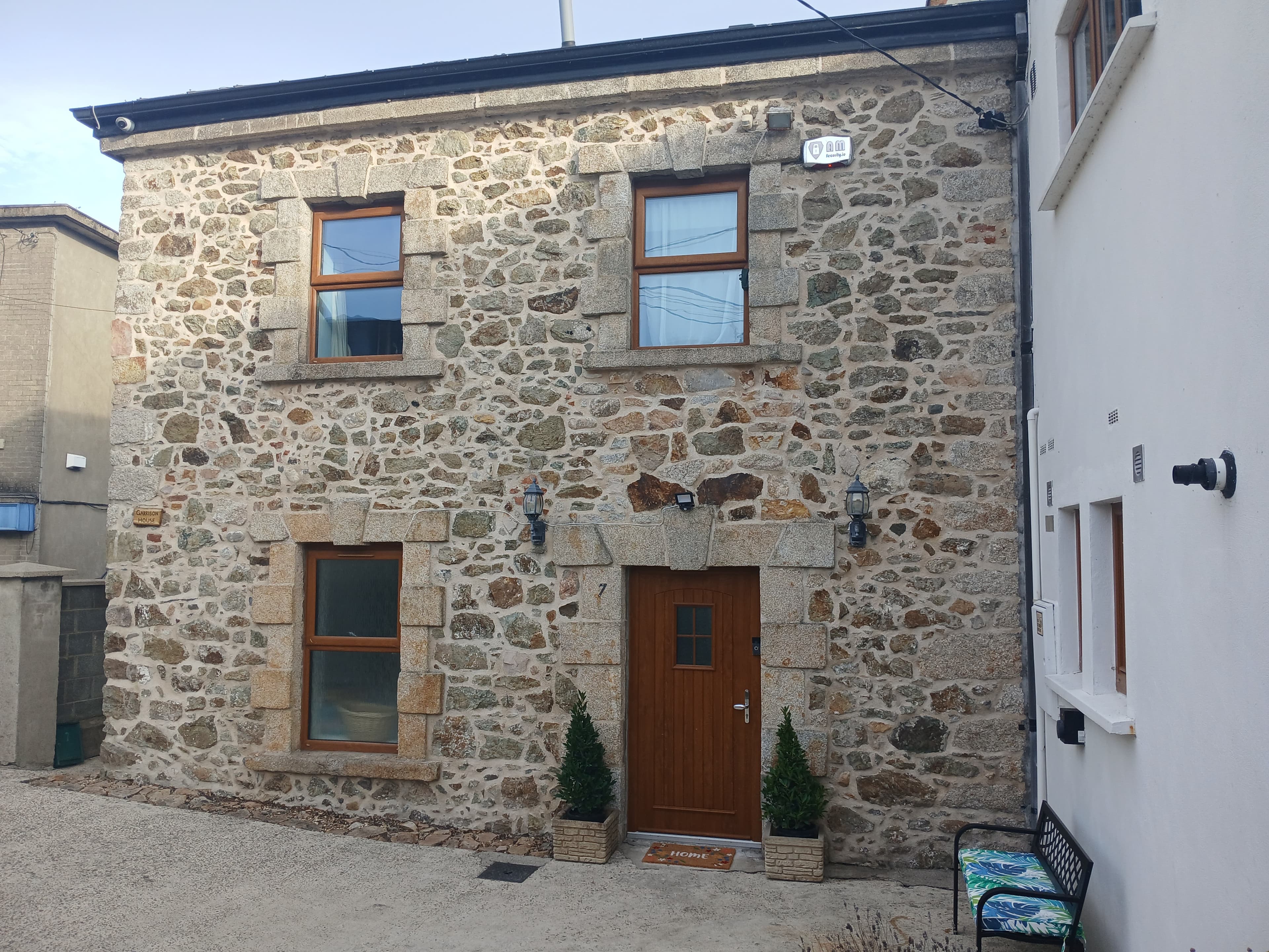 Front exterior of Garrison House with granite stone facade and timber door