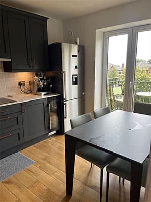 Kitchen and dining area with table, chairs and balcony doors