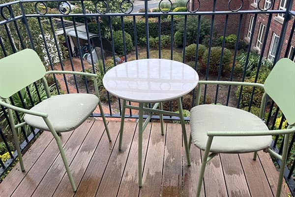 Private balcony with table and two chairs overlooking the grounds