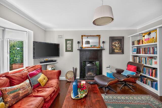Reception room with fireplace, bookshelves and armchair