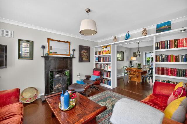 Reception room with fireplace and bookshelves opening to the dining area