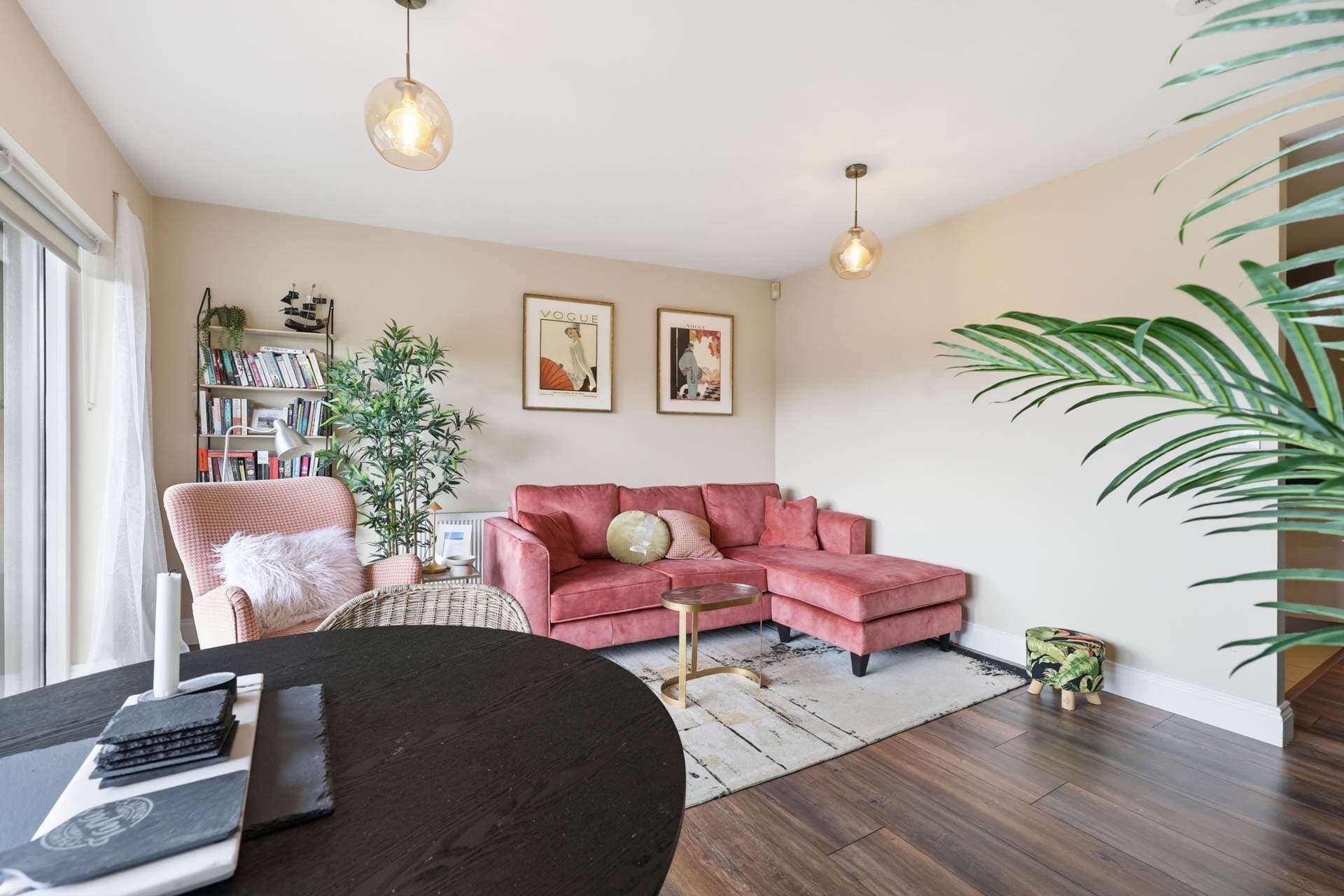 Living area with sofa, bookshelf and balcony doors