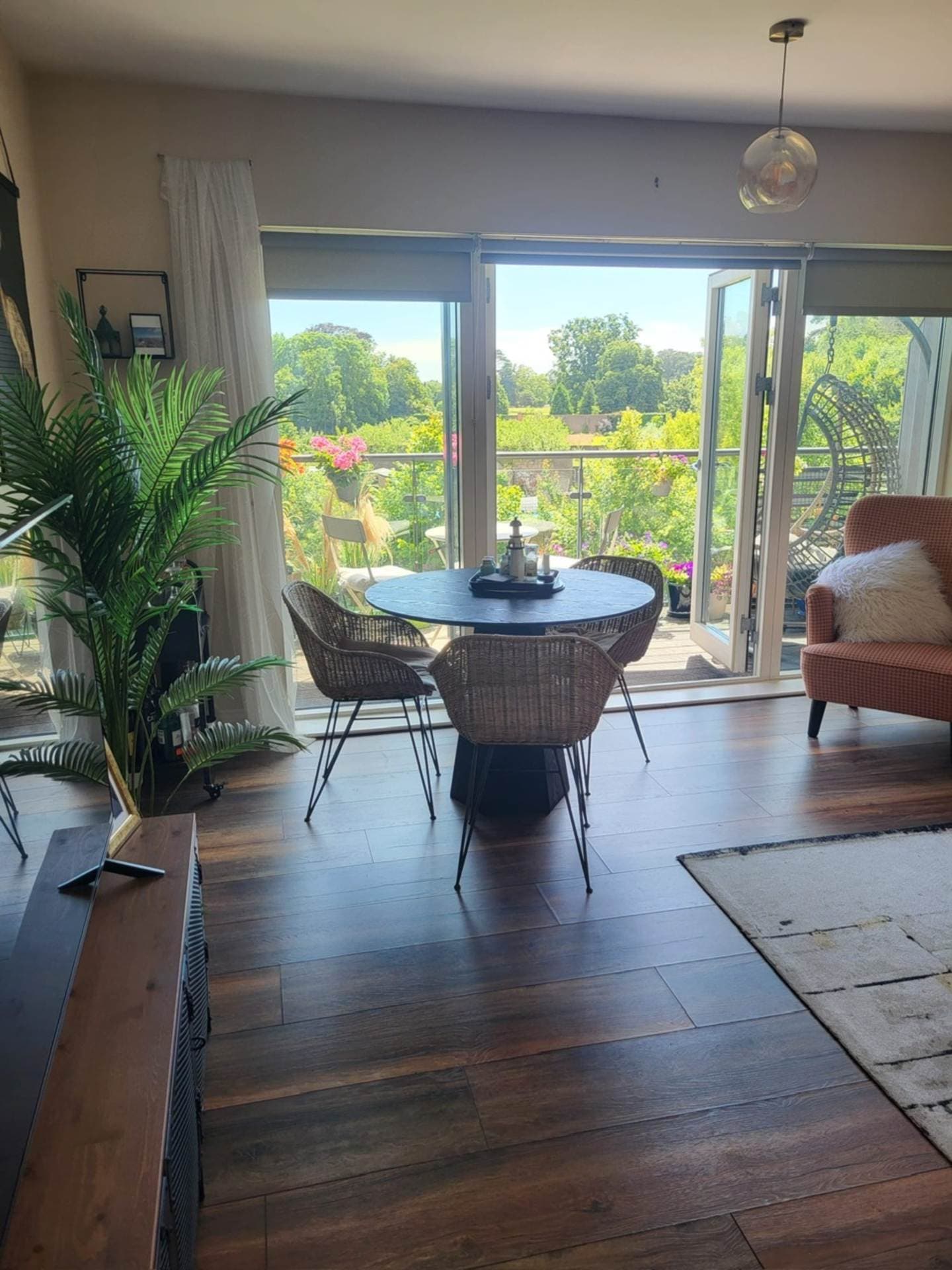 Dining area with table and chairs overlooking the balcony and gardens