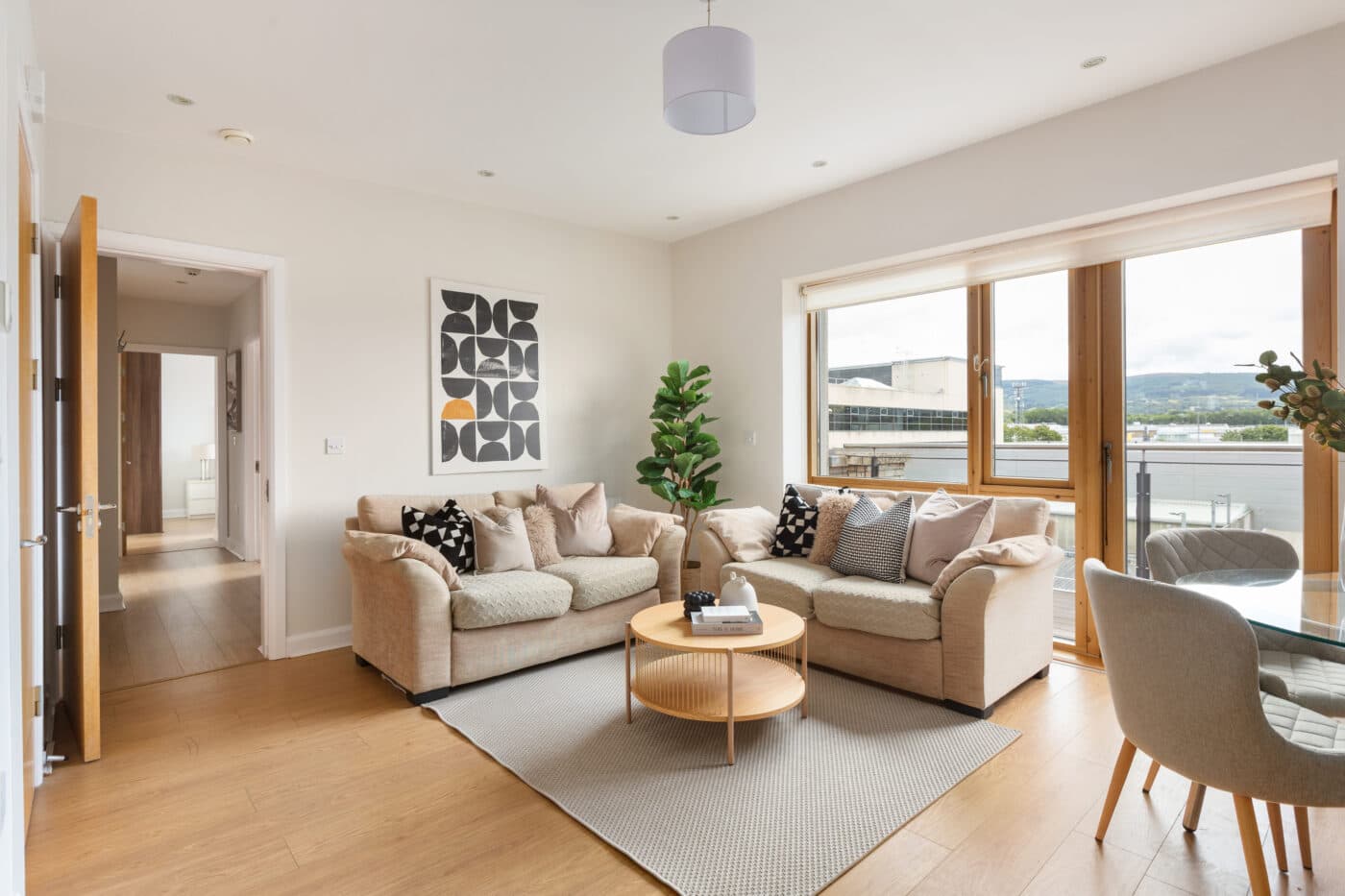 Living area with sofas and balcony doors opening onto views towards the Dublin Mountains